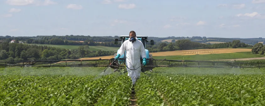 Salarié agricole appliquant un produit phytosanitaire sur une culture